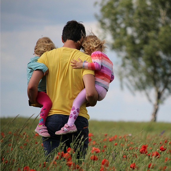 Padre con sus dos hijas a cuestas