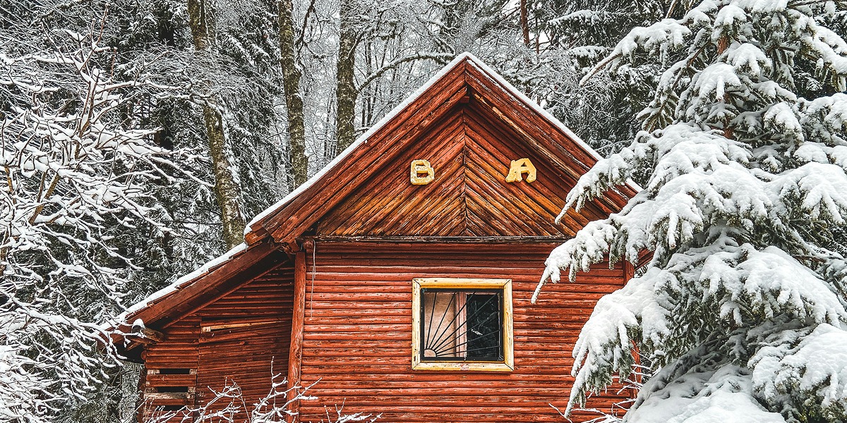 Cabaña en la montaña con nieve